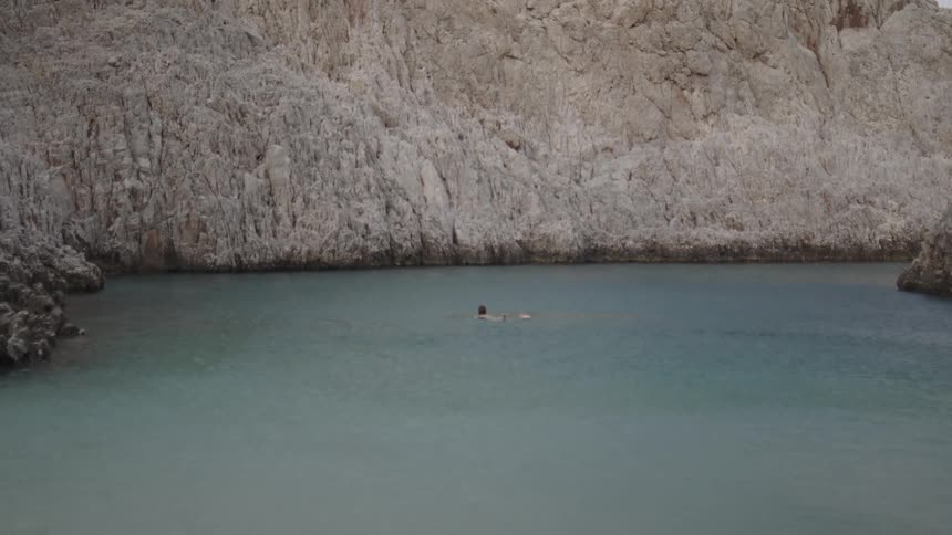 Person swimming in a lake during the day
