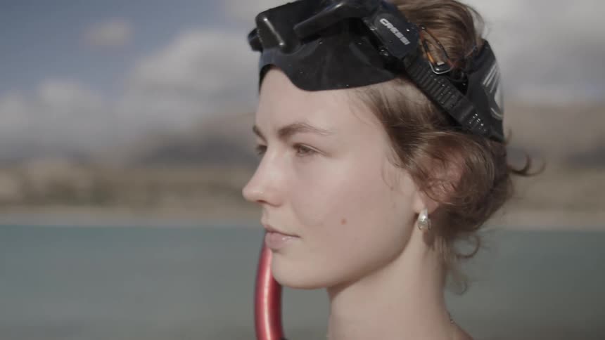 A young woman taking off her diving goggles