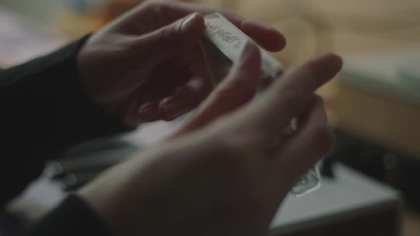 Woman labeling the case of a cassette tape