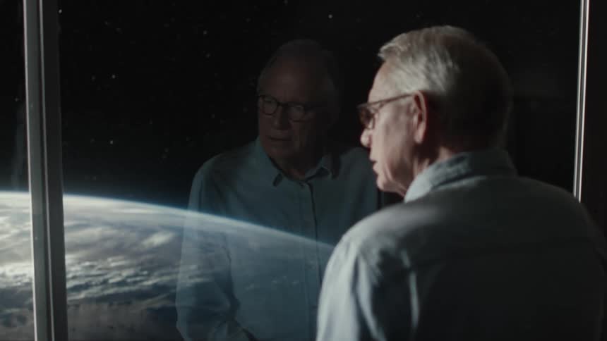 Elderly man casually dressed looking through a hotel sized window down at the earth from above with a disconcerted expression