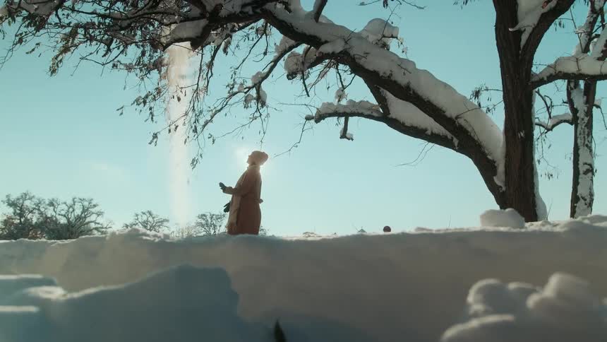 A woman outdoors playing with snow
