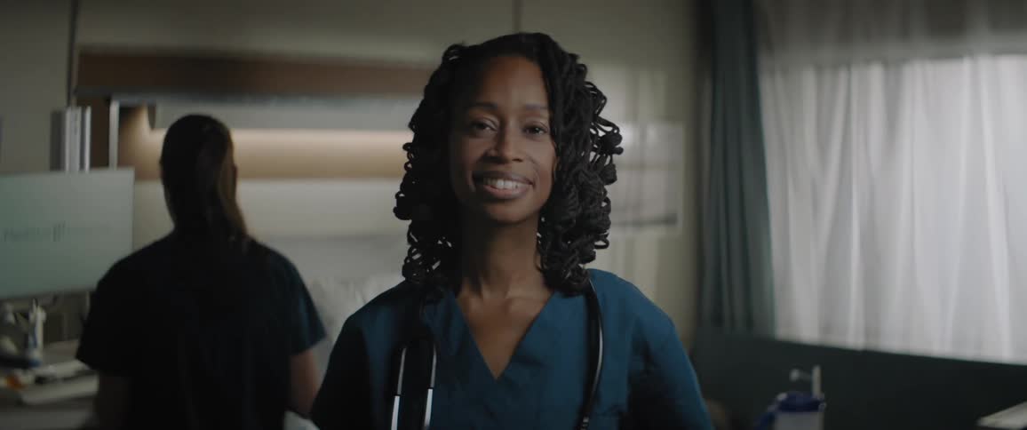 A nurse in surgical clothing in a hospital room