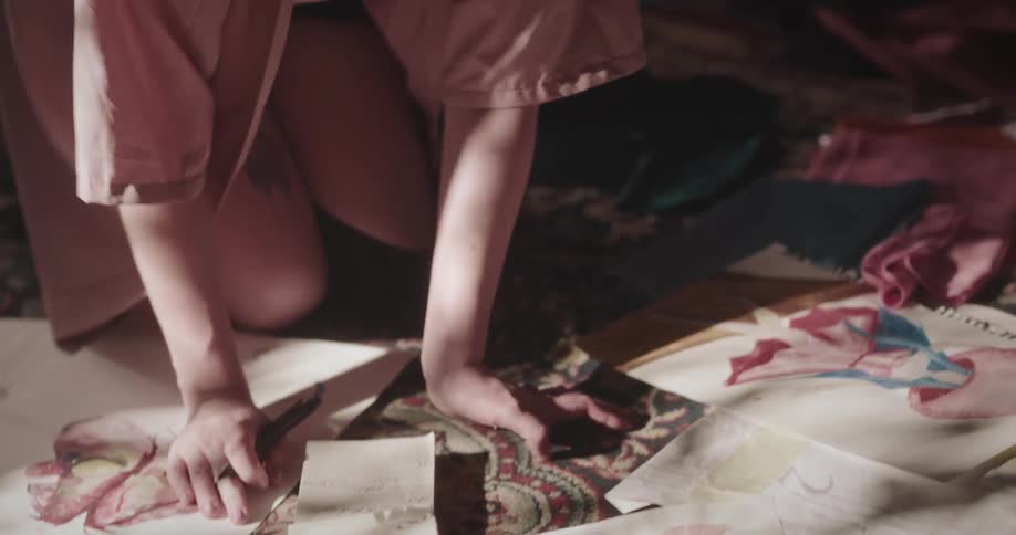 Woman crouched on the ground making notes in a notebook