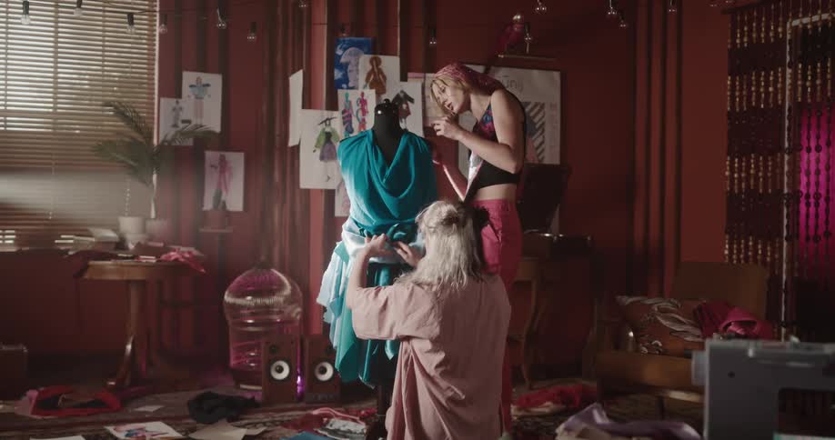 Two young fashion designers work together to make a dress