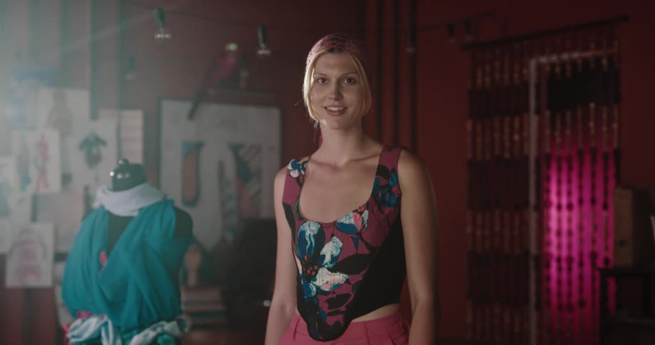 Woman designer stands indoors near dress form