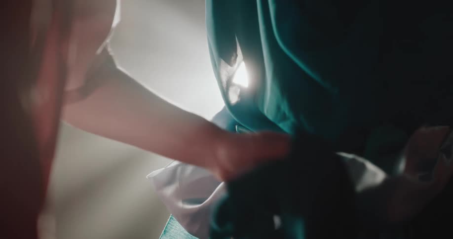Woman adjusting a dress with a bow on another womans back