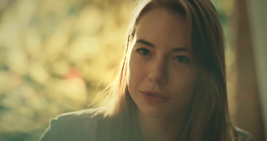 Blonde woman sits at table and talks with her friends