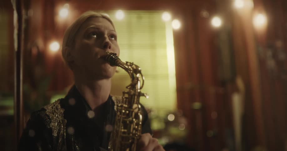 Woman plays the saxophone with feeling and completes her song