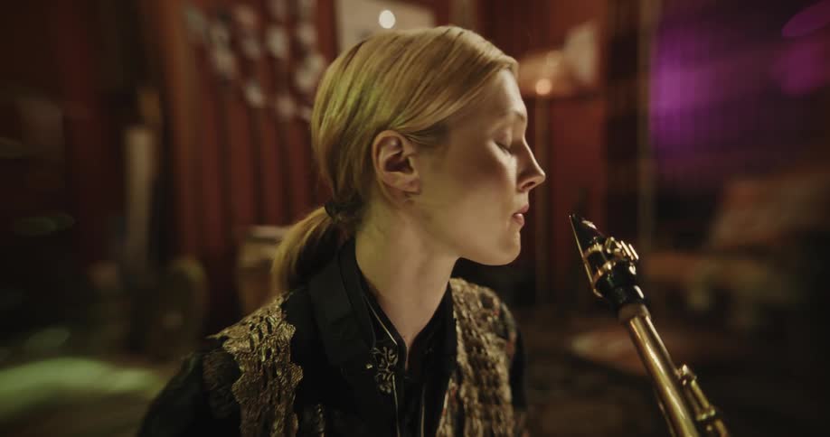 Blonde woman plays saxophone