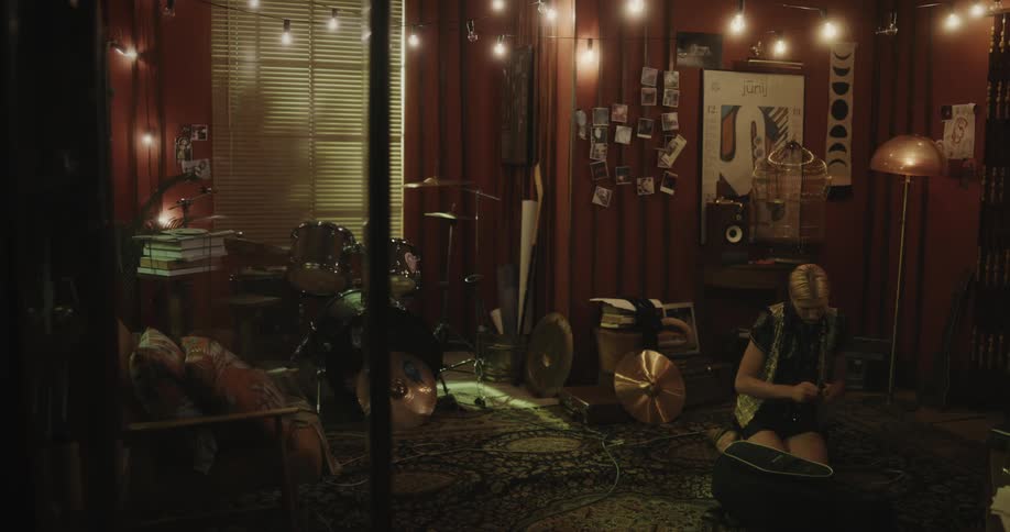 Female musician kneeling on floor in music room packs bag