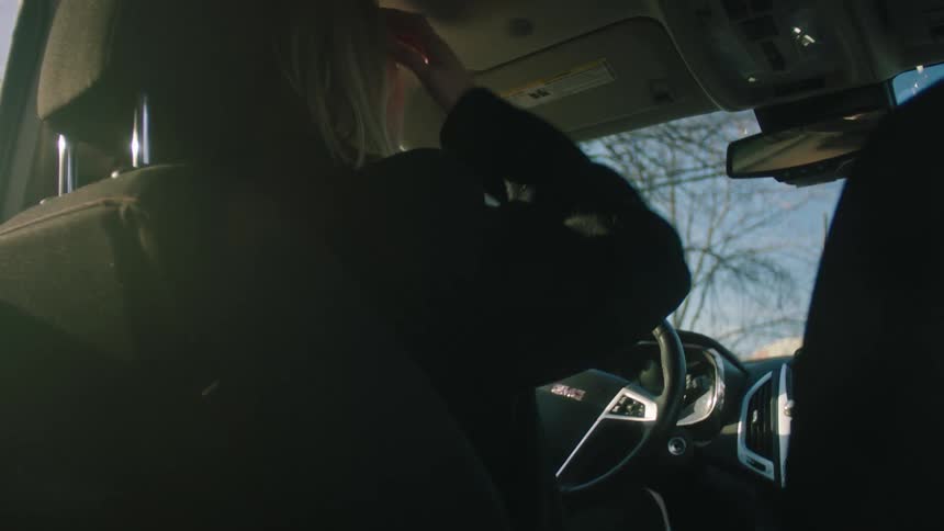 Woman inside the car slapping the steering wheel and placing her hands on her head