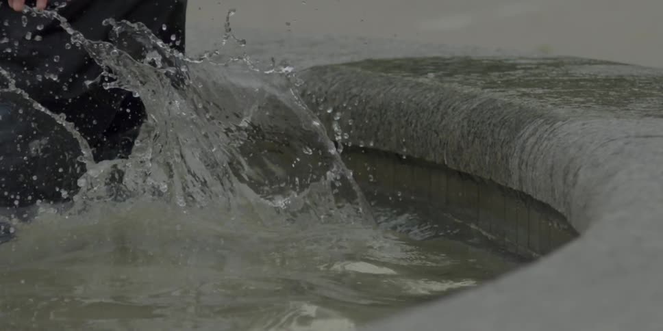 A child jumps in a pool and splashes playfully