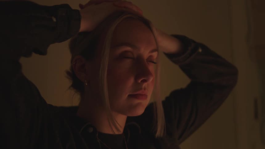 A nervous young woman with her hands on her head