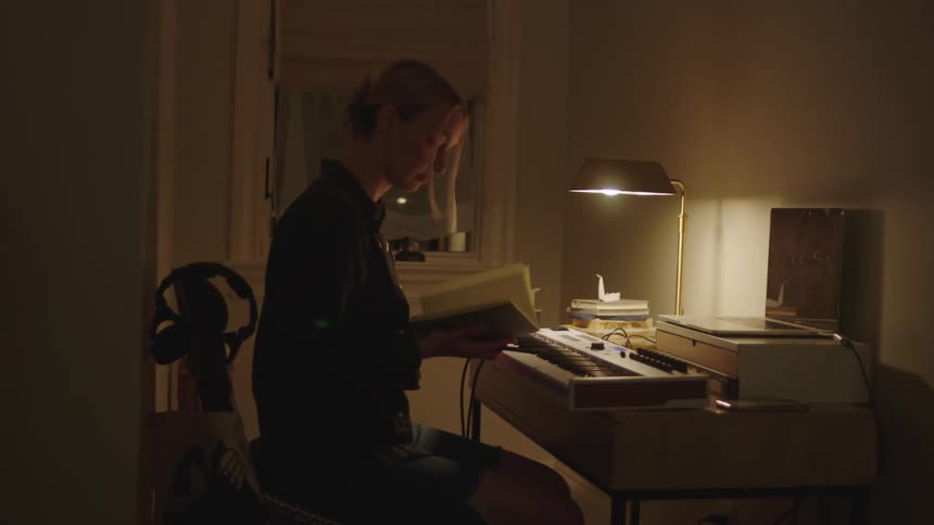 A female sitting at a desk flipping through a book