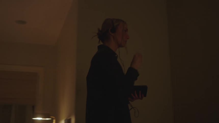Woman walking back and forth while listening to music on a portable device
