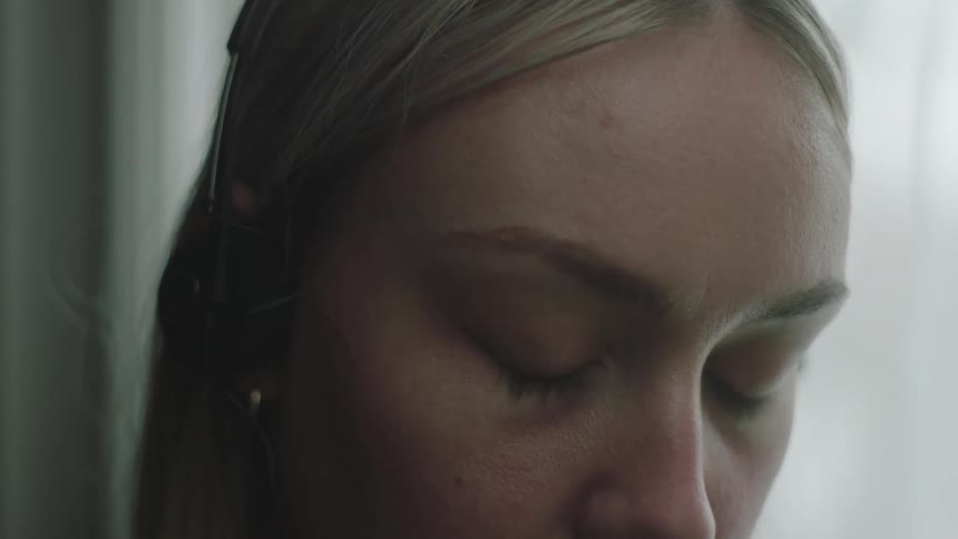 A woman listens to her headphones