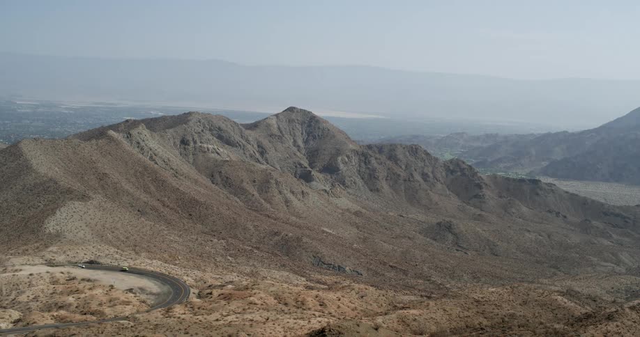 Traffic moves around a curve on a road near mountains