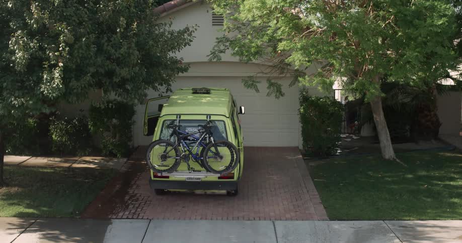 Two men get into the van with the bikes mounted on the back