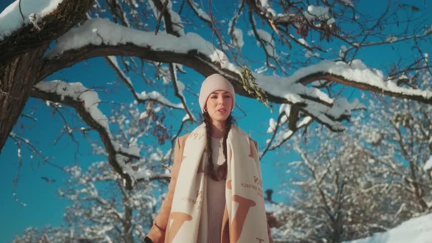 A woman knocking snow from a tree branch