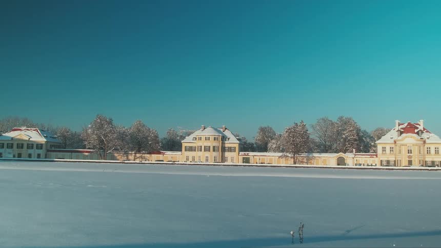 Panorama of residential houses facing a frozen field on a clear cloudless winter day
