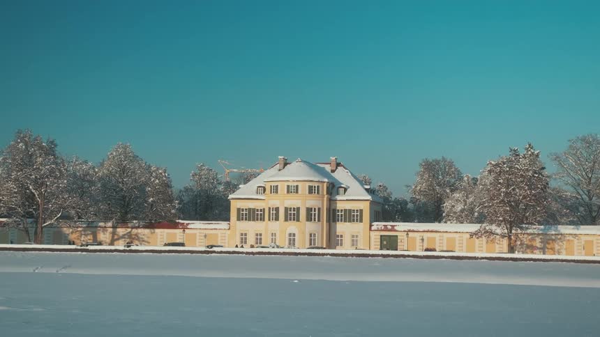 Yellow building with snow covered roof on cloudless day