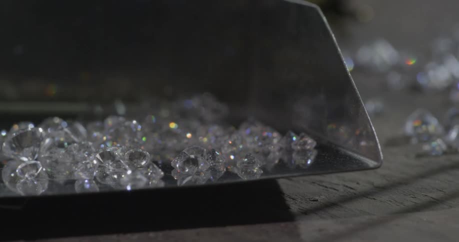 Sparkling diamonds sitting in a metal container