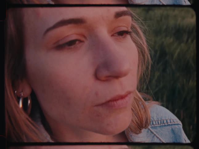 Close up of woman with a nose piercing and earrings in the field