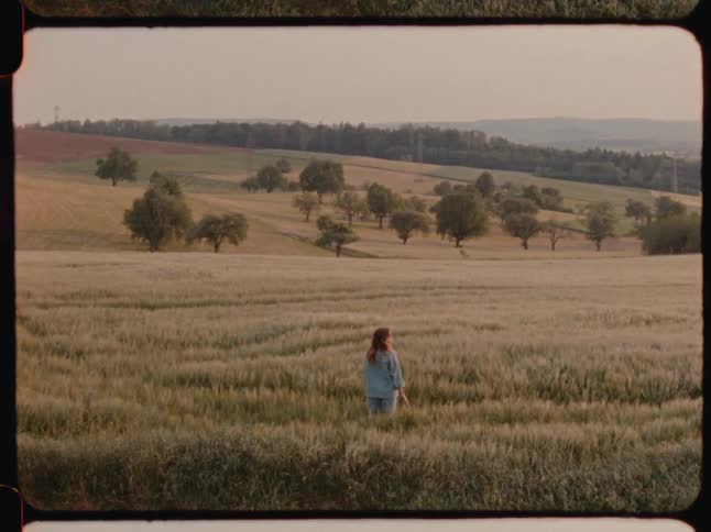 A woman standing in a meadow during the day