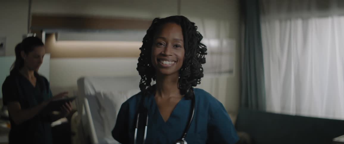 Female doctor smiling while standing in a hospital room during the day