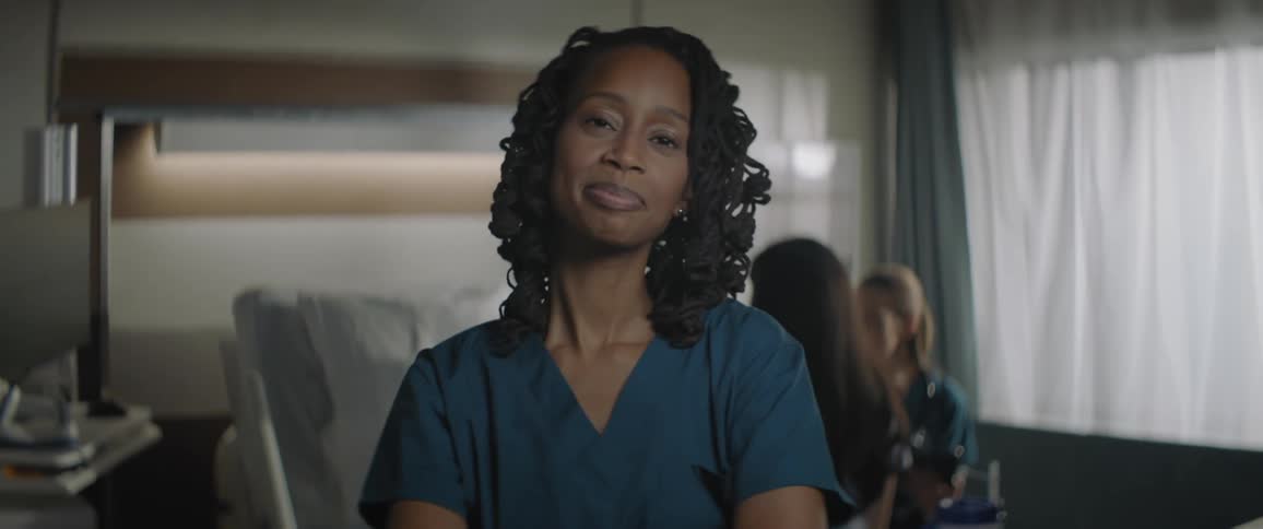 Portrait of a young nurse with some people in the background