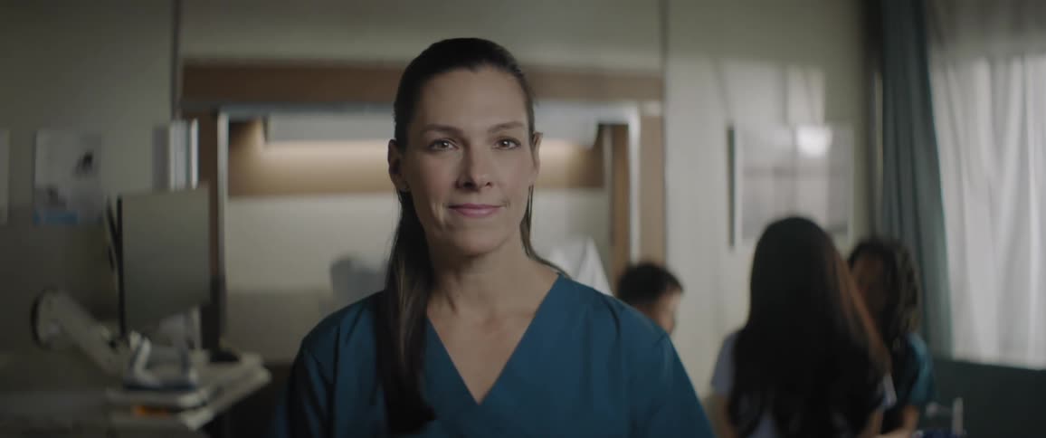 A female healthcare worker poses for the camera while indoors