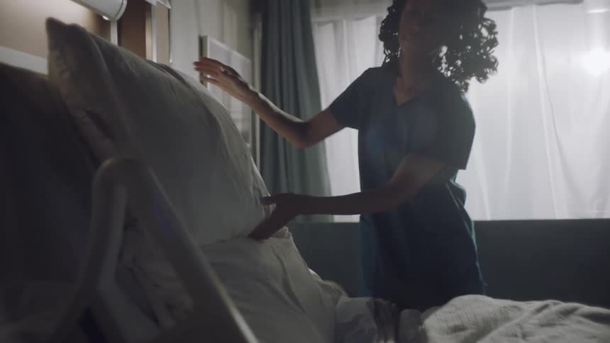 Nurse makes a bed in a hospital room