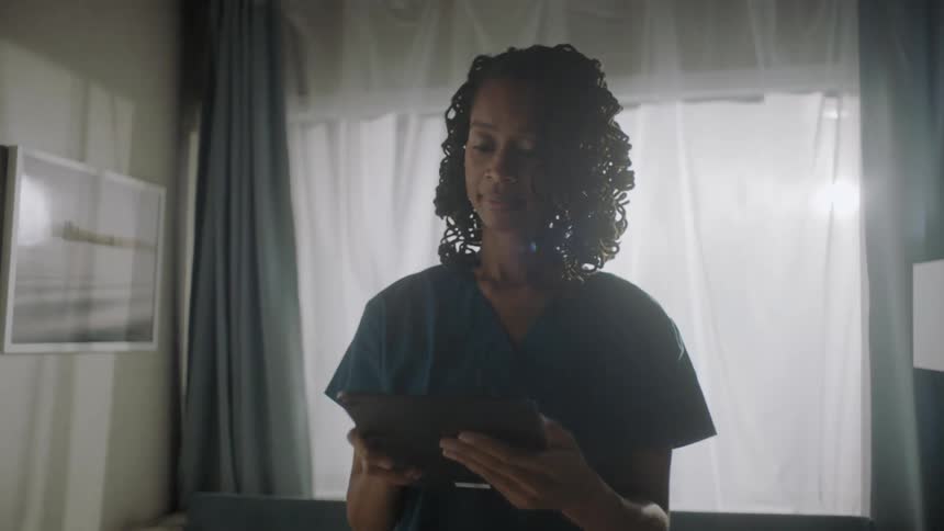 Portrait of a nurse standing and using a tablet
