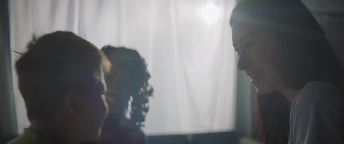 Portrait of two women smiling and talking with a boy