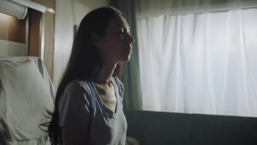 A woman is sitting in the hospital bed