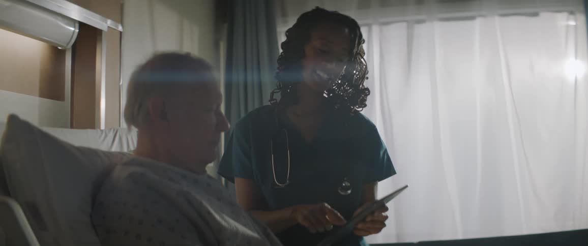 Nurse talks to a patient in a hospital room