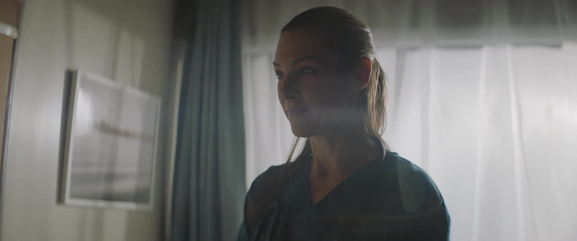 Medical professional wearing scrubs nods and talks during a conversation