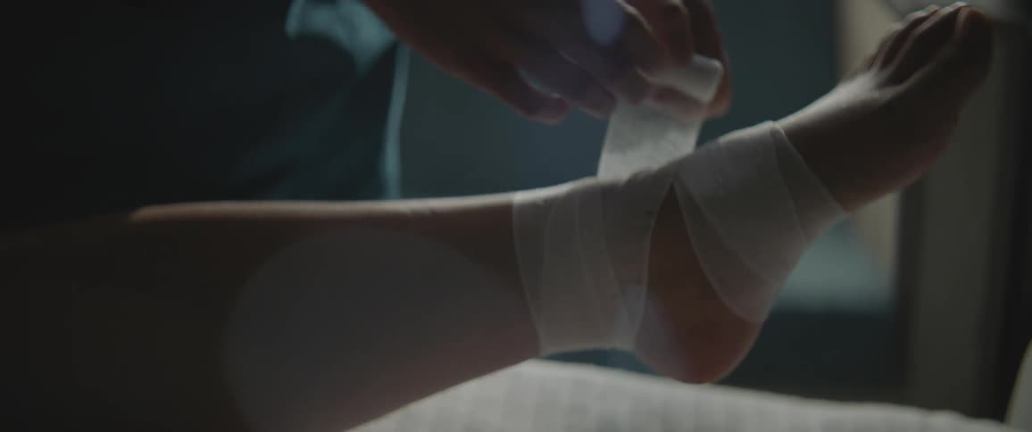 A person bandaging someone elses foot and ankle
