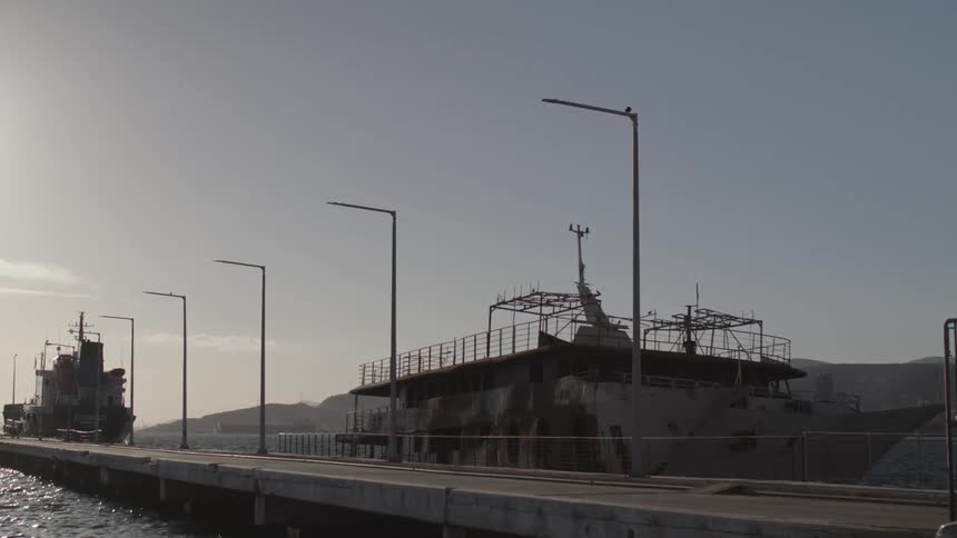 A sea platform in a marina with a ship docked