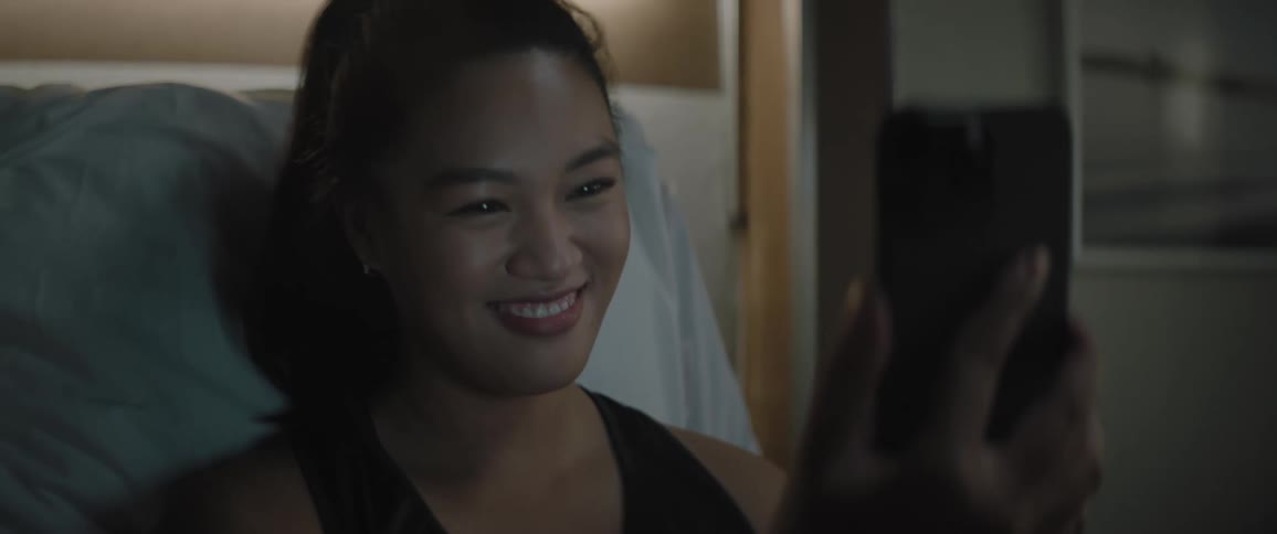 Lady smiling while video calling on mobile phone indoor at night