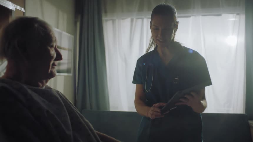 Nurse talks to a patient in a hospital room
