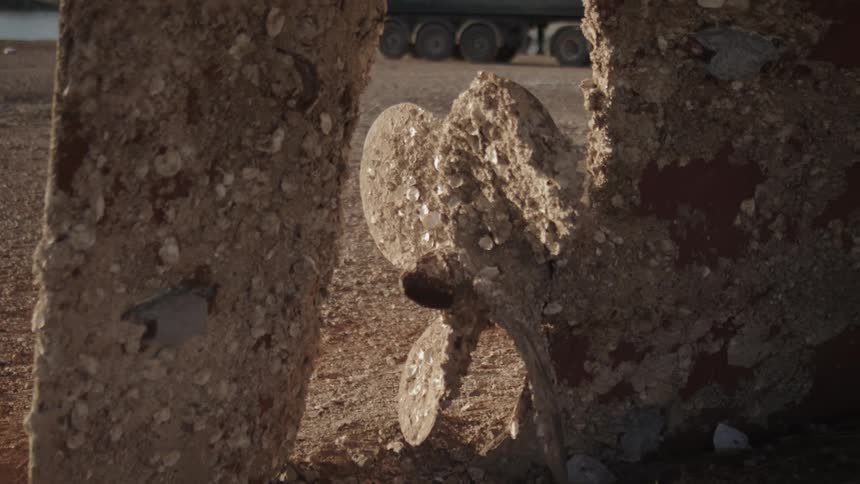 An old propeller with dust dirt and glass solidified around it
