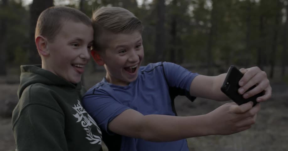 Two kids take their photograph with a camera