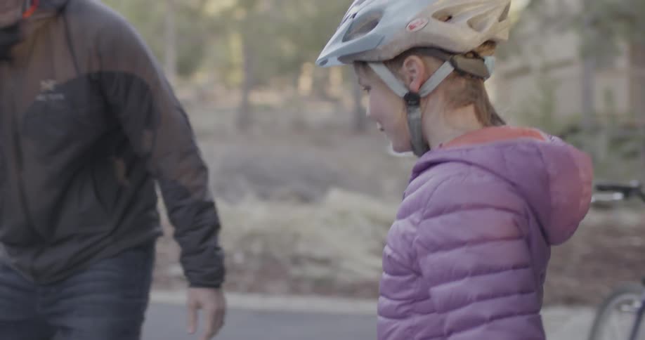 A man pushes a child's bake out of a garage for a young girl