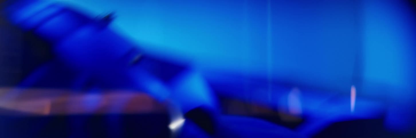 Helmet of race car driver standing next to car reflects surrounding blue light