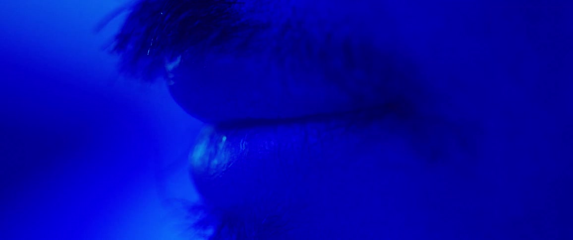 A mans lip that smiles and has blue coloring