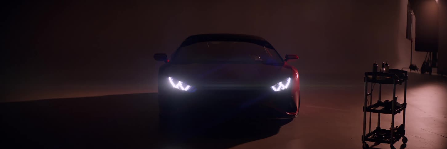 A car with headlights on shining in the dark