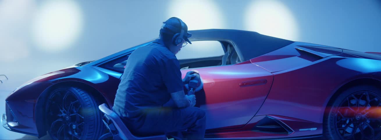 Man polishing the side of a red ferrari
