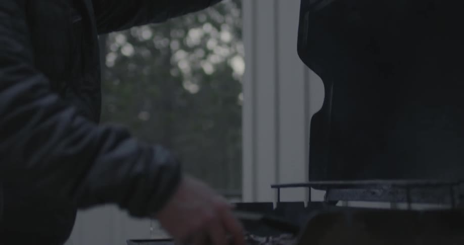 A man cooks food on a grill outside