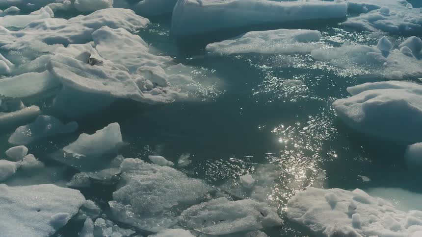 Closeup of the sea with solar reflection amid the ice